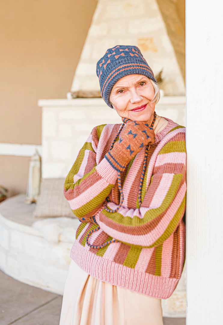 Older woman wearing knitted sweater, mitts and hat