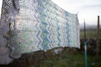 white knitted shawl hanging on clothesline