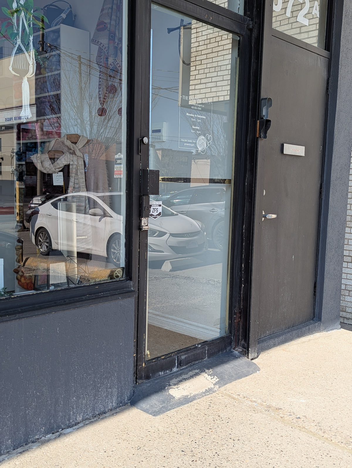 Front door of store with small concrete ramp at base