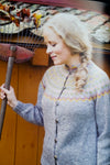 Woman holding rake wearing bue knitted sweater