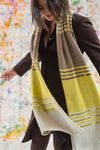 Woman wearing wide brown and yellow knitted scarf