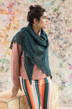 Woman wearing colourful pants, and blue knitted shawl
