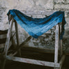 Blue knitted shawl hanging on wooden horse