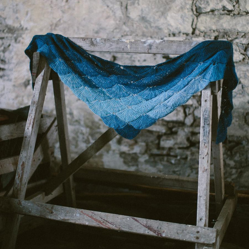 Blue knitted shawl hanging on wooden horse
