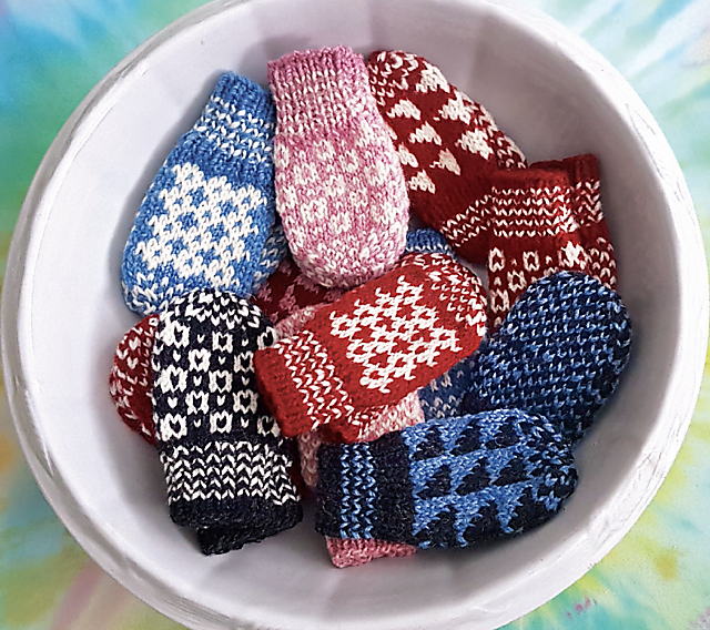Colourful mittens in a white bowl