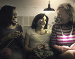 Three women sitting, laughing an knitting