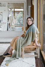 Woman in knitted shawl sitting on chair