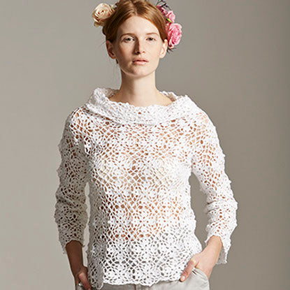 Young woman wearing white knitted sweater with roses in her hair