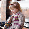 Young girl sitting on bench wearing knitted sweater